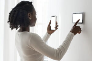 Woman pressing on smart home automation panel monitor