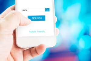 Hand holding mobile phone with search page on screen with mobile