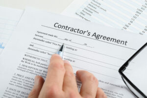 Hand With Pen And Eyeglasses Over Agreement