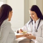 Female,Friendly,Doctor,Examining,Hand,Skin,Of,Young,Woman,Patient.